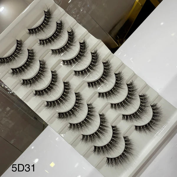 Set of false eyelashes on a marble surface with a blurred background