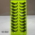 Green box containing false eyelashes with a neutral background