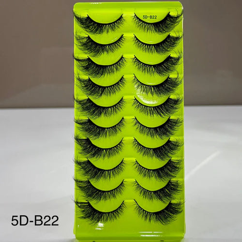 Green box containing false eyelashes with a neutral background