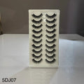 Set of false eyelashes in a box on a reflective surface with a neutral background