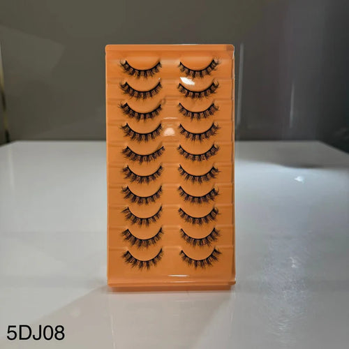 Set of false eyelashes on an orange display card with a blurred background