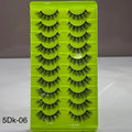 Set of false eyelashes in a green case with a gray background
