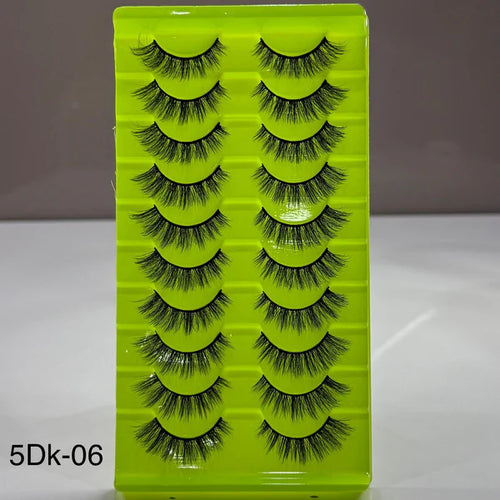 Set of false eyelashes in a green case with a gray background