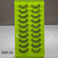 Set of false eyelashes on a green tray with a gray background