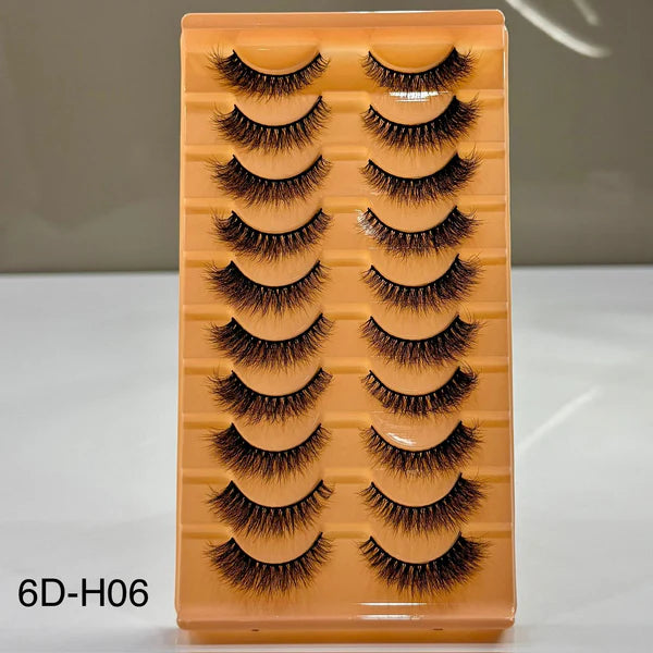 Set of false eyelashes on a wooden tray with a neutral background