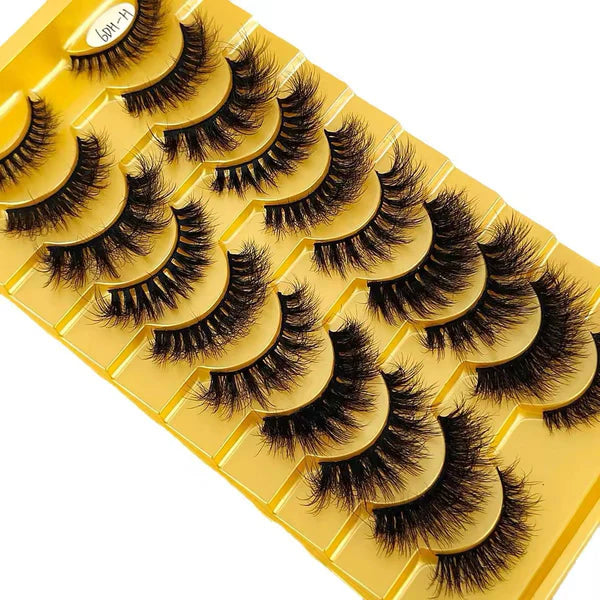 Set of false eyelashes on a yellow tray with a white background