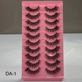 Pink tray with false eyelashes on a gray background