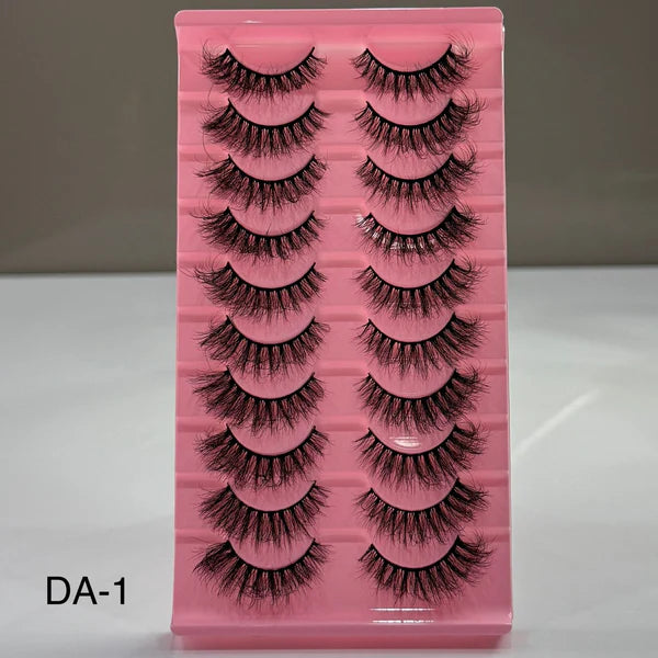 Pink tray with false eyelashes on a gray background