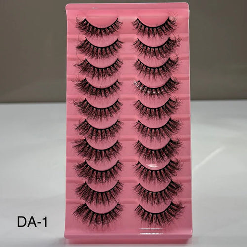 Pink tray with false eyelashes on a gray background
