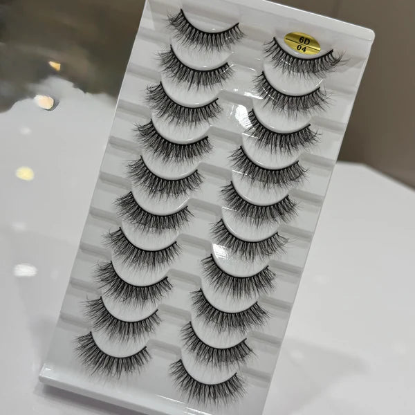 Set of false eyelashes on a gray packaging with a marble pattern.