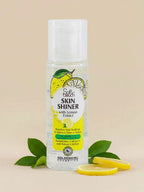 Bottle of GoldenGirl Cosmetics Skin Shiner with Lemon Extract on a beige background with lemon slices and leaves.