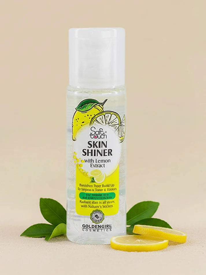 Bottle of GoldenGirl Cosmetics Skin Shiner with Lemon Extract on a beige background with lemon slices and leaves.