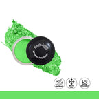 Green sparkling dust in a small container with visible brand name on a white background