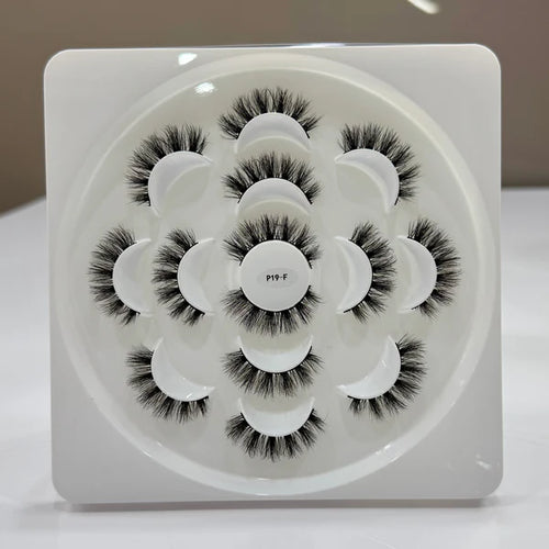 Set of false eyelashes in a white display case on a neutral background