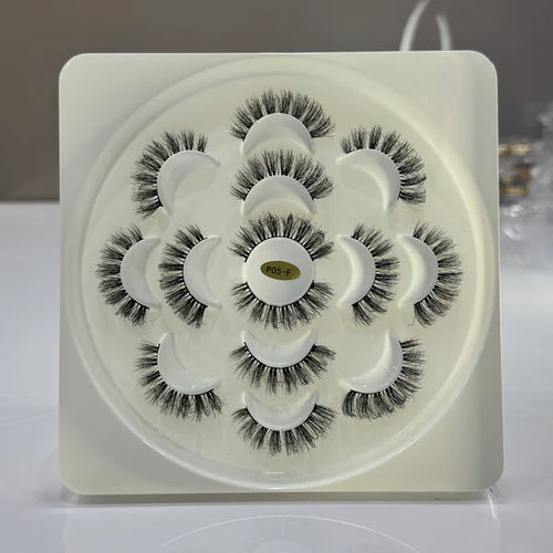 Set of false eyelashes in a white tray on a light background