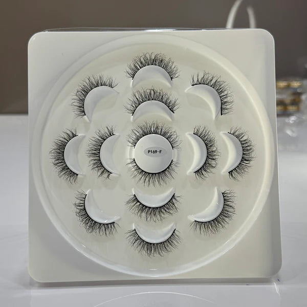 Set of false eyelashes in a white tray with a gray background