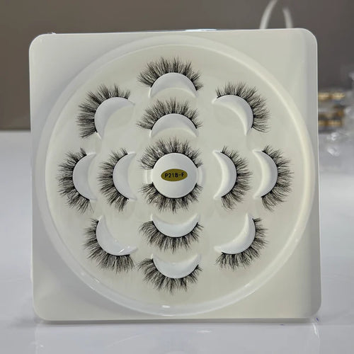 Set of false eyelashes in a white container with a gray background