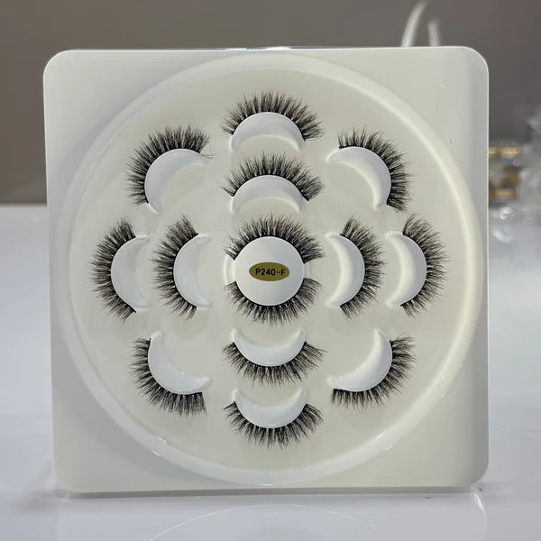 Set of false eyelashes in a white container with a gray background