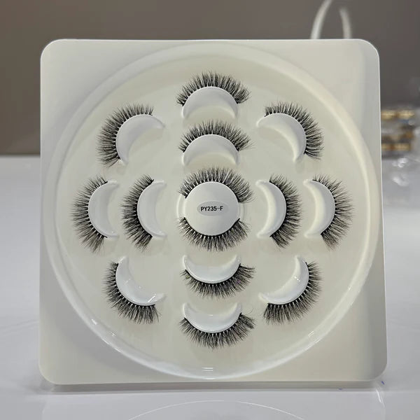 Set of false eyelashes in a white tray on a light gray background