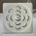 Set of false eyelashes on a white tray with a neutral background