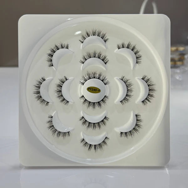 Set of false eyelashes on a white tray with a brand label.