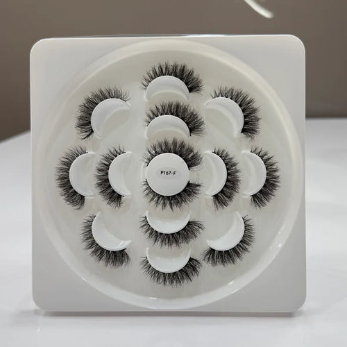 Set of false eyelashes in a circular tray on a white background