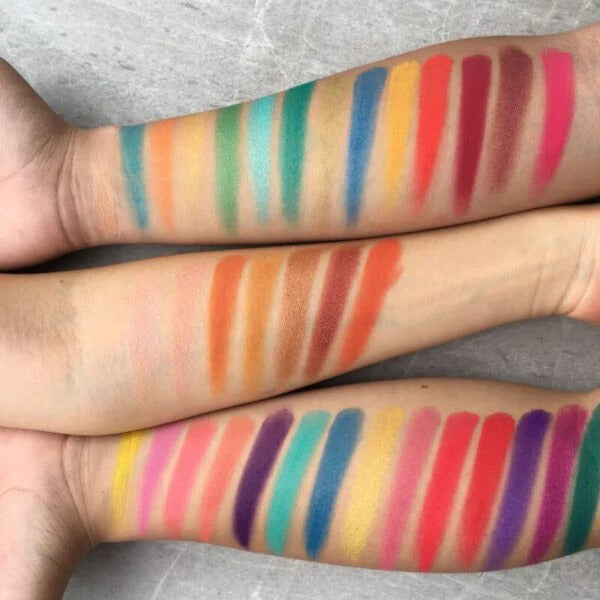 Color swatches of lipsticks on a person's arm with a gray background