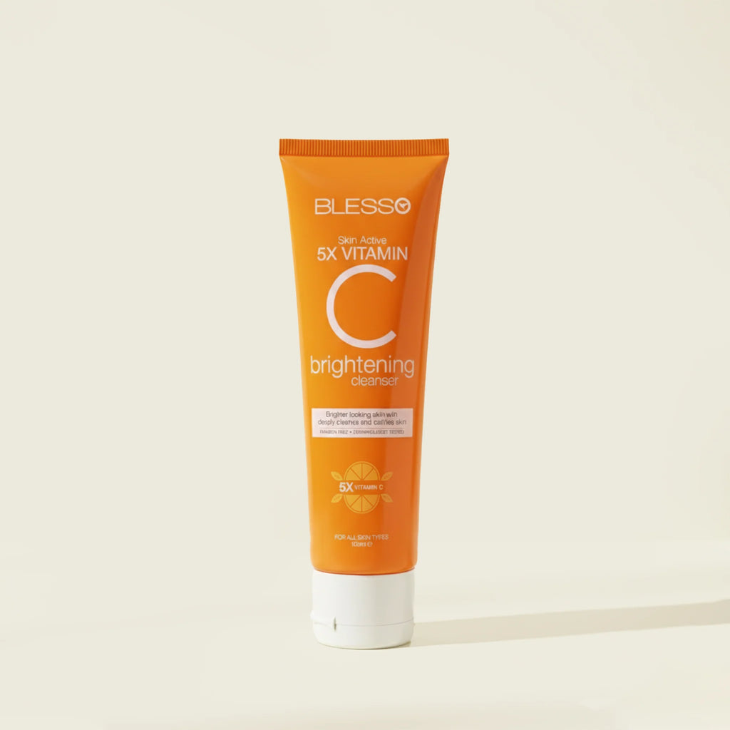 Orange tube of Blesso Vitamin C brightening cleanser on a beige background