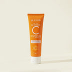 Orange tube of Blesso Vitamin C brightening cleanser on a beige background