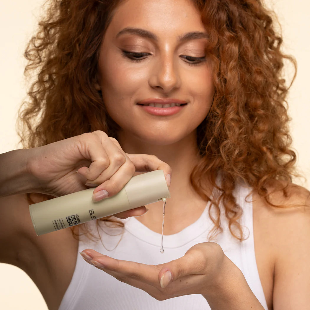 Woman holding a Blesso skincare product with a beige background