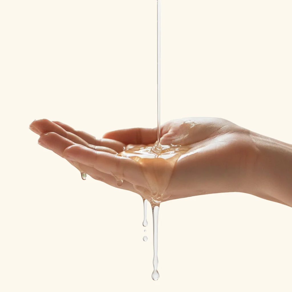 Hand receiving a stream of Blesso liquid on a white background