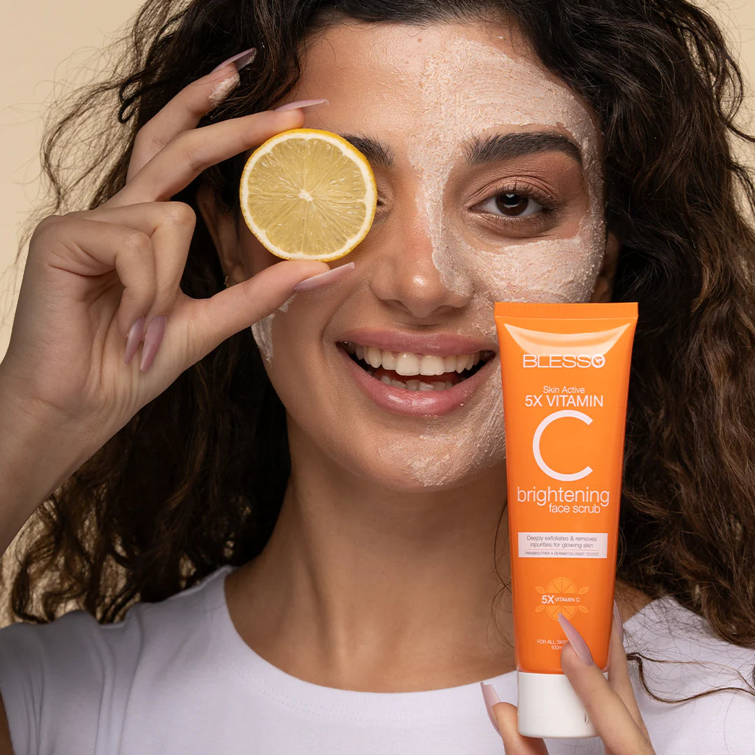Woman with a face scrub holding a lemon and a Blesso tube of Eucerin brightening facial scrub.