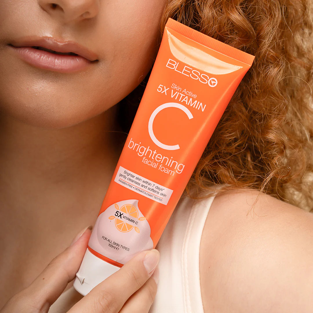 Person holding a tube of Blesso Skin Active 5X Vitamin C brightening facial foam.