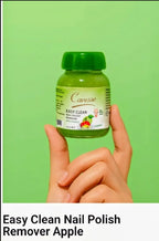Hand holding a bottle of Carresse Easy Clean Nail Polish Remover Apple against a green background