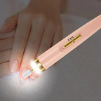 Pink and gold pen with a light on a white surface