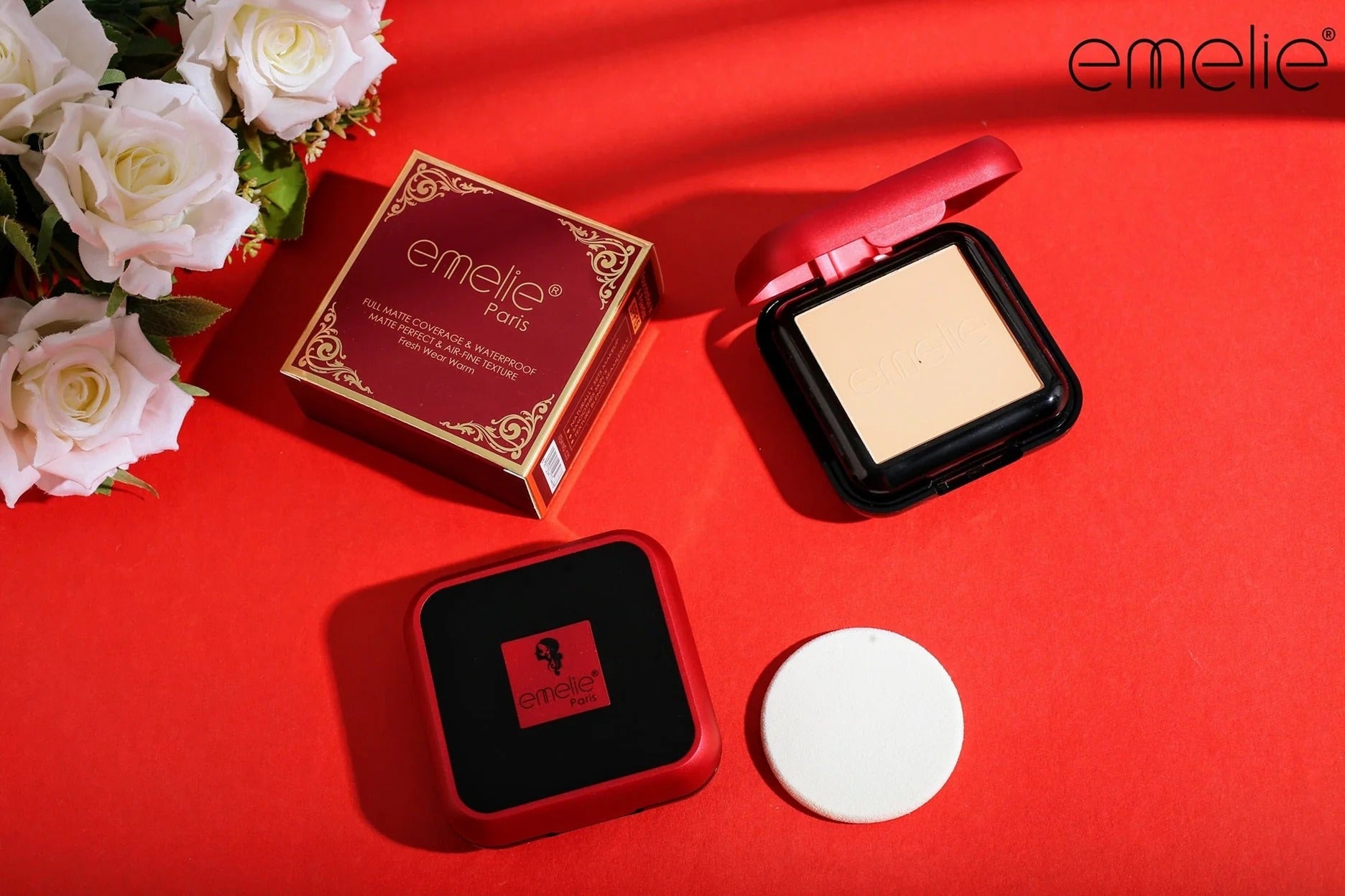 Makeup product with 'emelie' branding on a red background with flowers.