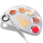 Metallic makeup palette with colorful shades and a brush on a white background