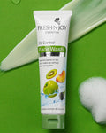 Tube of Fresh N' Joy Oil Control Face Wash on a green background with fruits and bubbles.
