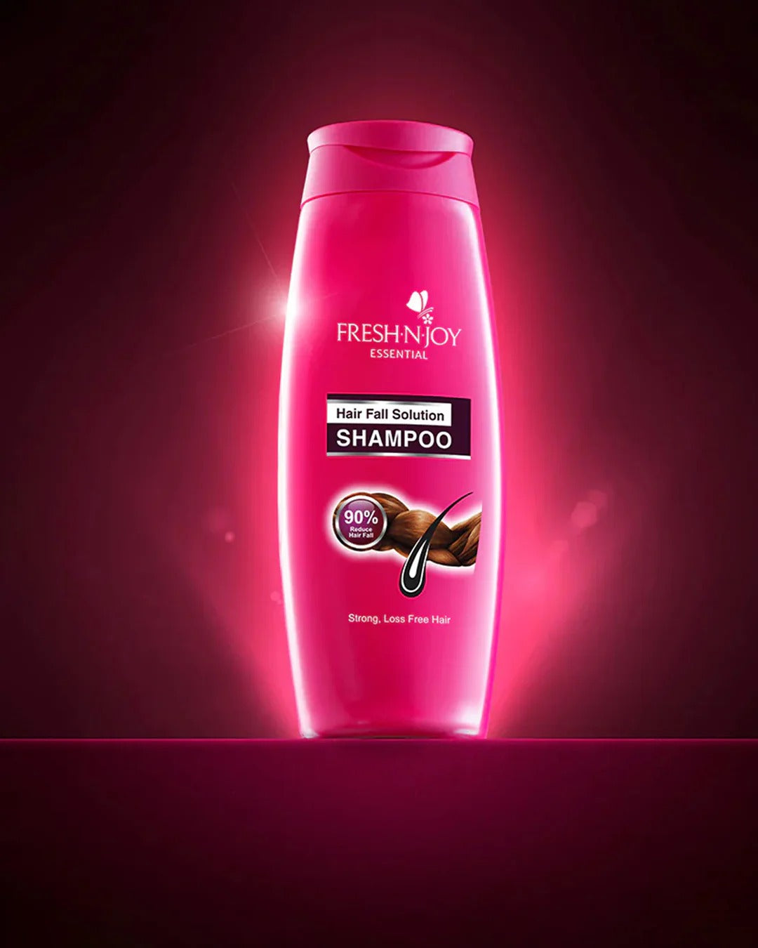 Pink shampoo bottle labeled 'Fresh'n'Joy' on a dark red background