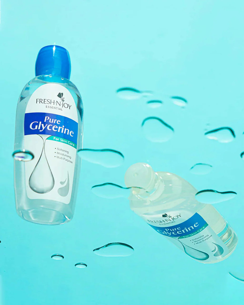 Bottle of Fresh'n'Joy Pure Glycerine on a blue background with water droplets.