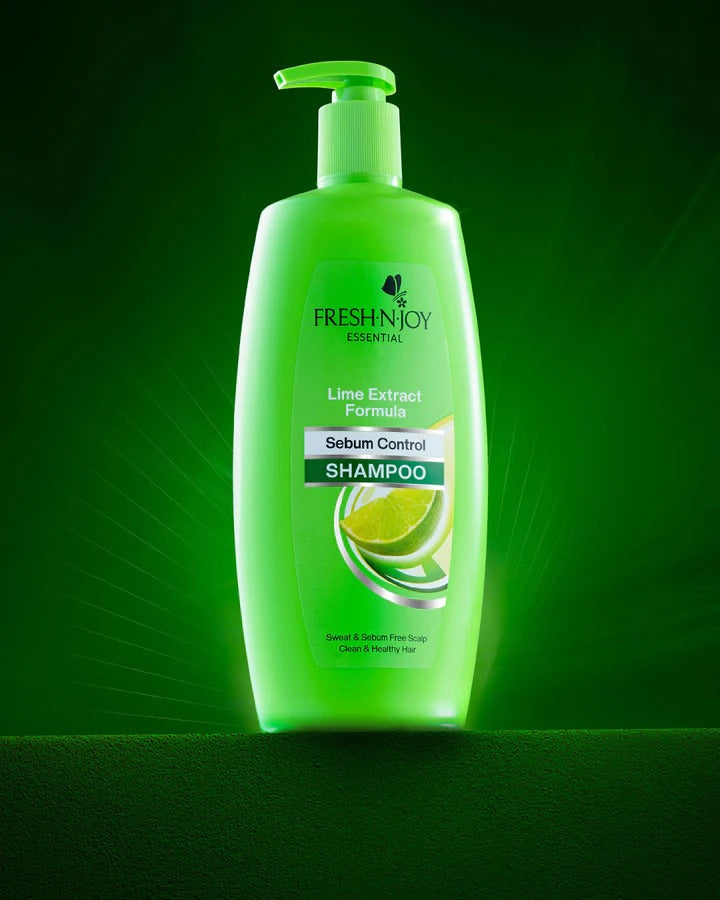 Green bottle of Fresh N' Joy Lime Extract Formula Shampoo on a green background