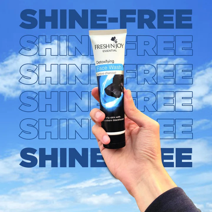 Hand holding a tube of Fresh 'N' Joy face wash against a blue sky background with text.