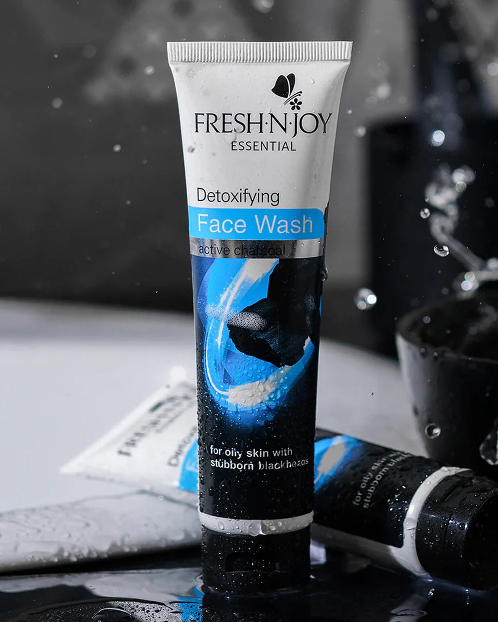 Tube of Fresh N' Joy Detoxifying Face Wash with water droplets and a blurred background