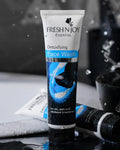 Tube of Fresh N' Joy Detoxifying Face Wash with water droplets and a blurred background