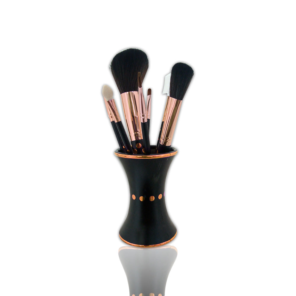 Set of makeup brushes in a black holder on a white background