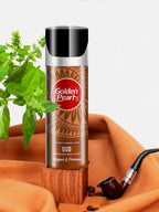 Golden Pearl Oud perfume bottle with a plant and pipe on an orange surface