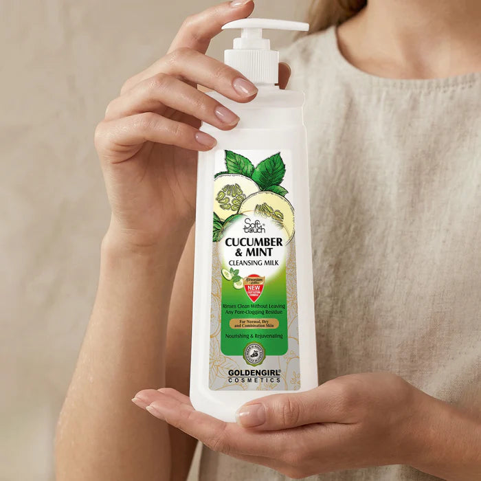 Person holding a bottle of Golden Girl Cosmetics Cucumber & Mint Cleansing Milk against a neutral background