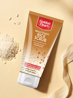 Golden Pearl Brightening Rice Scrub tube on a beige background with rice grains.