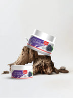 Two containers of Golden Pearl Double Action Cleanser on a white background with a wooden log.