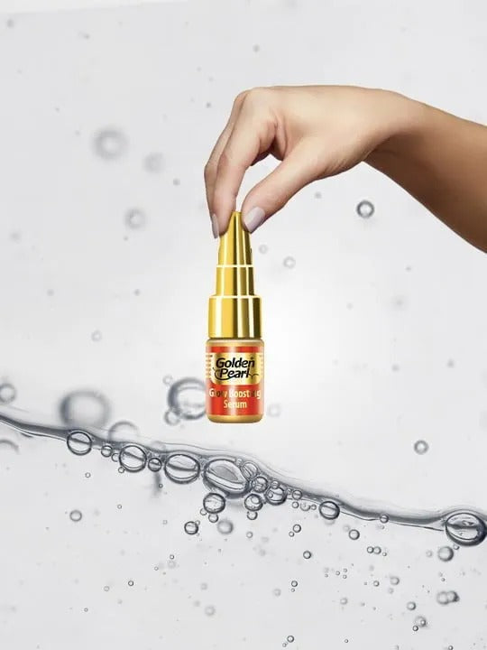 Hand holding a Golden Pearl bottle with water droplets in the background